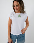 Close-up of white sleeveless Jersey top with model wearing green tree necklace