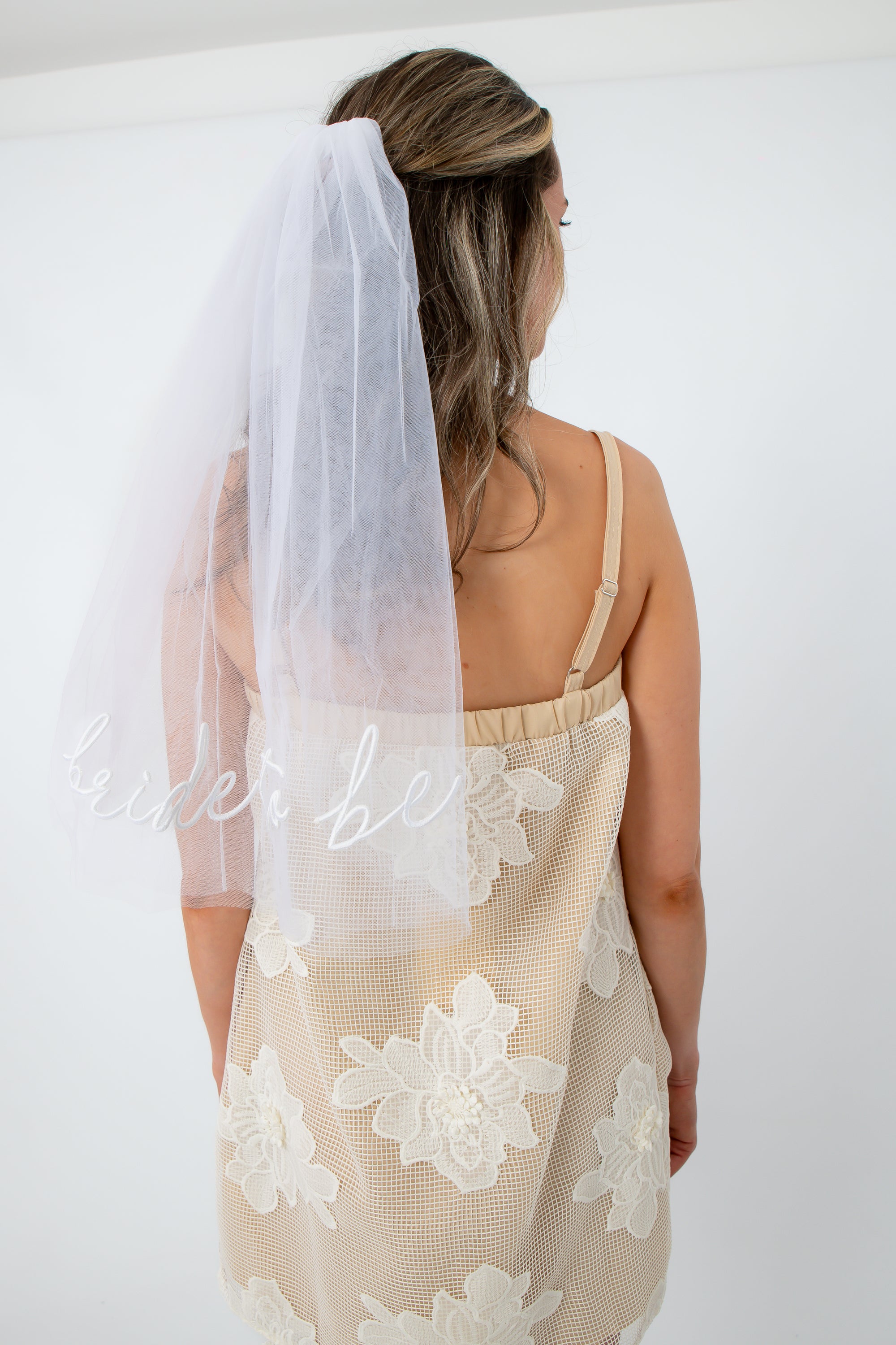 Back view of bride wearing embroidered veil with floral lace details for bridal shower