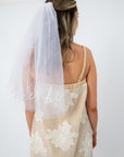 Back view of bride wearing embroidered veil with floral lace details for bridal shower
