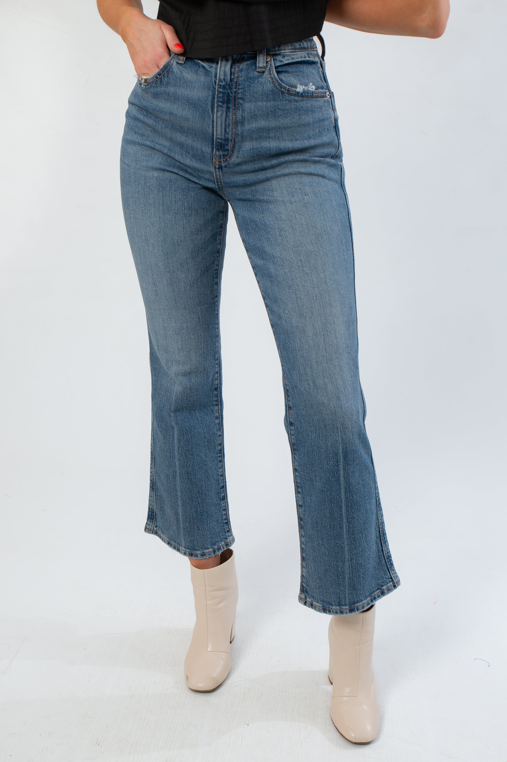 Daze Denim Rush Hour Soho High Rise Ankle Flare jeans in medium wash with flared hem and high-rise fit, styled with cream ankle boots.