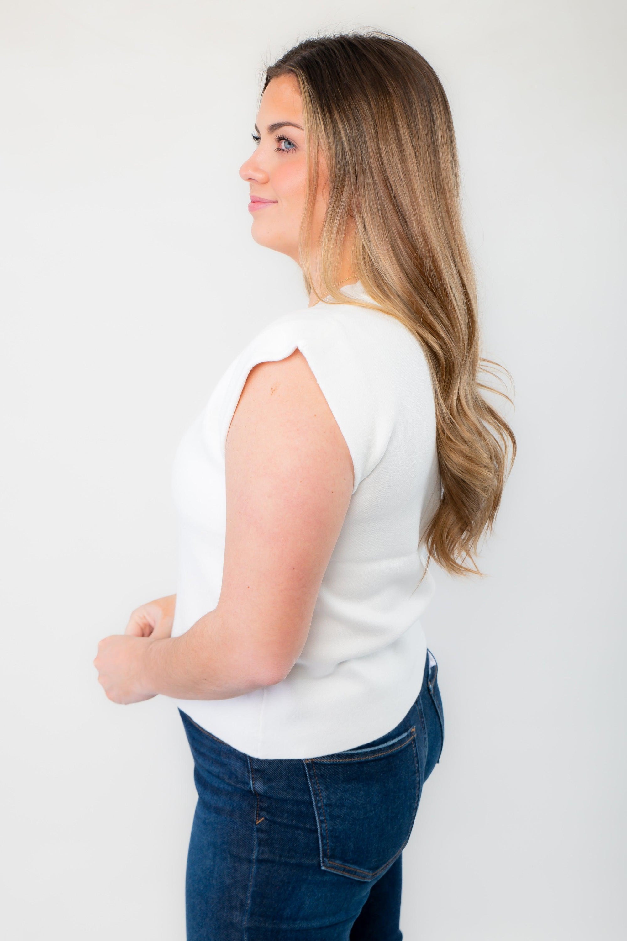 Side profile of the Dally White Muscle Sweater Tank, highlighting its structured cap sleeves and tailored fit for a polished look.