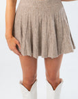Close-up of pleated mini skirt from Call Me Back Skirt Set-Dark Taupe Knit. Soft knit texture adds comfort and style to fall wardrobe.