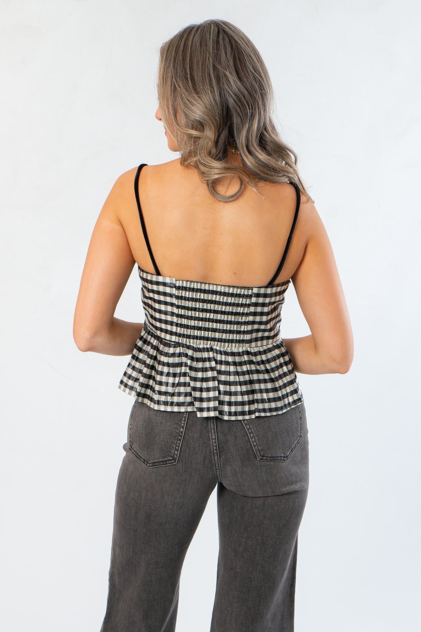 Back view of Girly Girl Shiny Black Gingham Peplum Top highlighting smocked back and peplum silhouette for a chic finish.