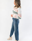 Side view of Mountain Top Stripe Knit Sweater showing pastel stripe pattern and comfortable fit, styled with casual denim and boots.