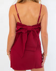 Back view of Jodie Burgundy Dress featuring a large statement bow and adjustable spaghetti straps for a custom fit.