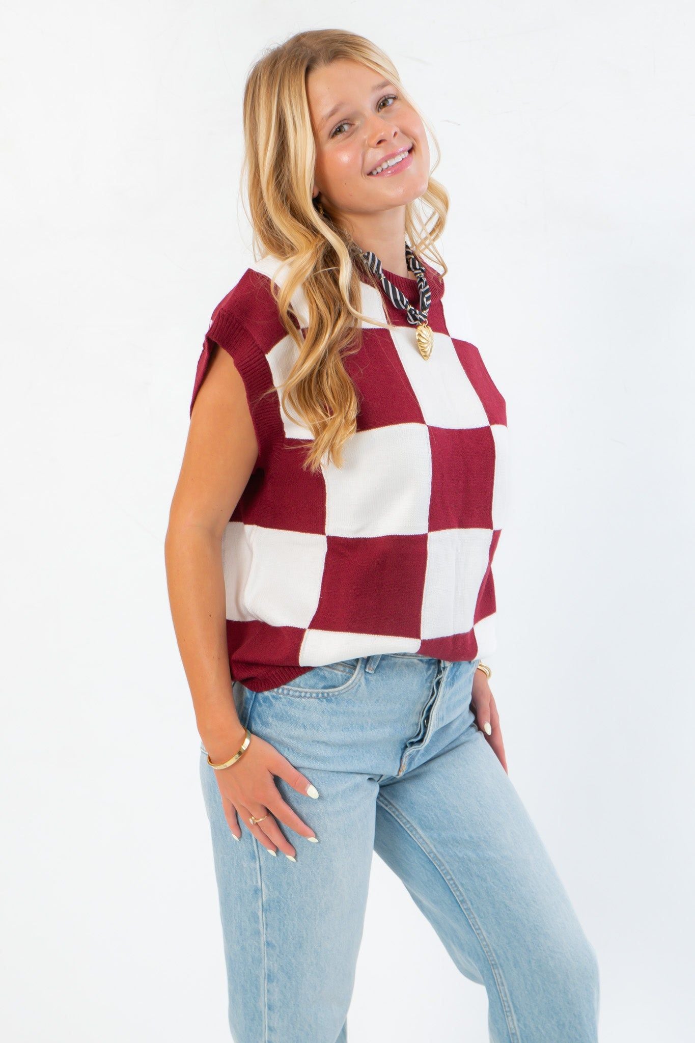 Side angle of Checkmate Burgundy Sweater Vest highlighting its sleeveless cut and burgundy checkerboard pattern, perfect for layering in fall.