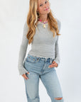 Lightweight Free People Heather Grey Oh My Darling Long Sleeve shirt featuring ruffled hem and fitted silhouette, ideal for layering in cooler seasons.