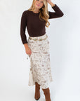 Old West Satin Maxi Skirt – Cream Satin with Western Icons paired with a dark sweater and brown boots, showcasing fall fashion in western style.