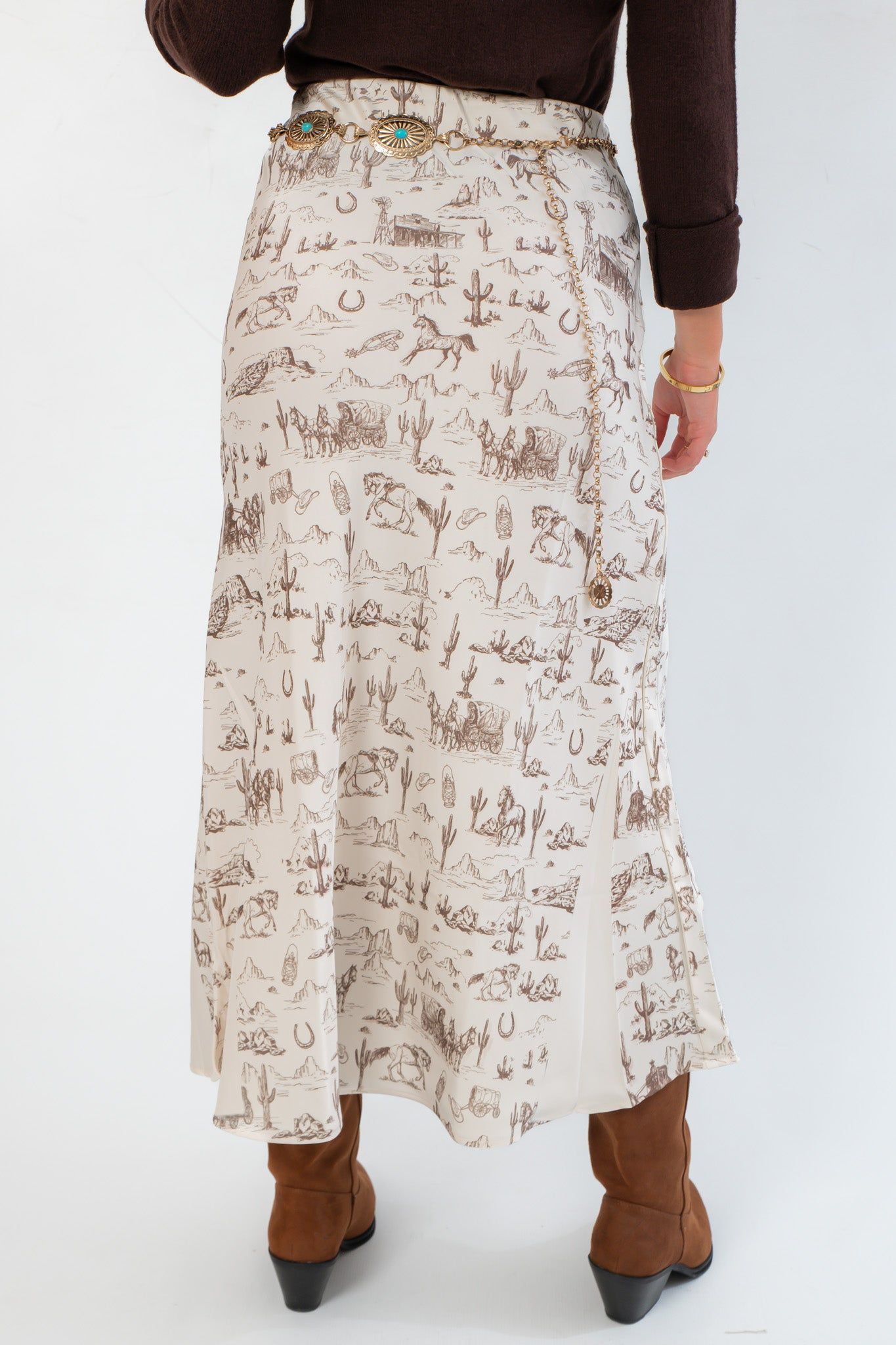 Detailed rear view of Old West Satin Maxi Skirt – Cream Satin with Western Icons, highlighting the flowing silhouette and intricate western motifs.