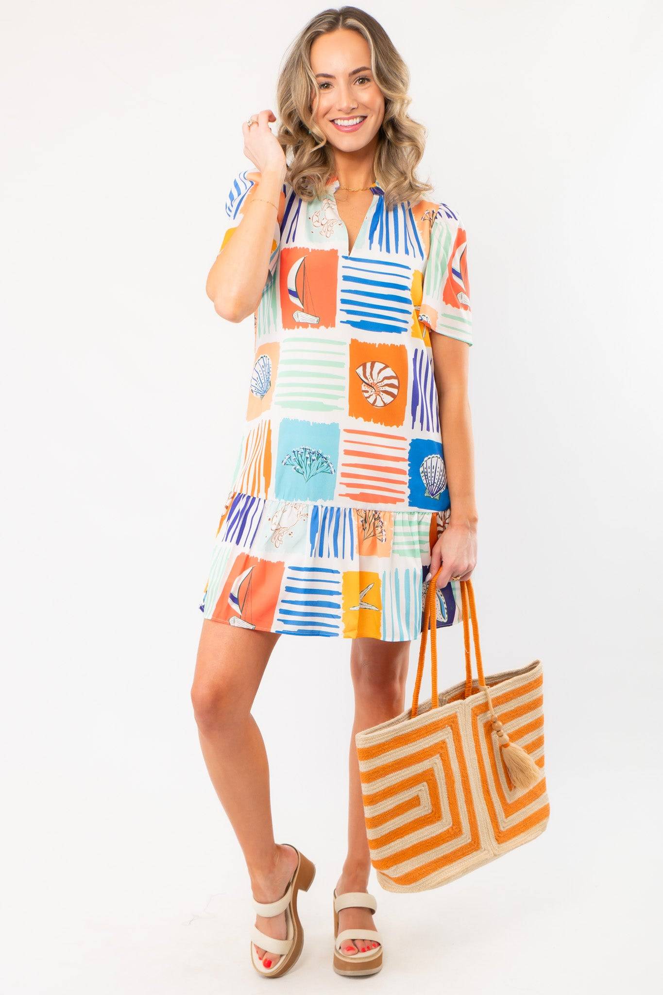 Discover seaside chic with THML At Sea Nautical Printed Dress featuring colorful ocean-themed blocks, short sleeves, and a relaxed fit.