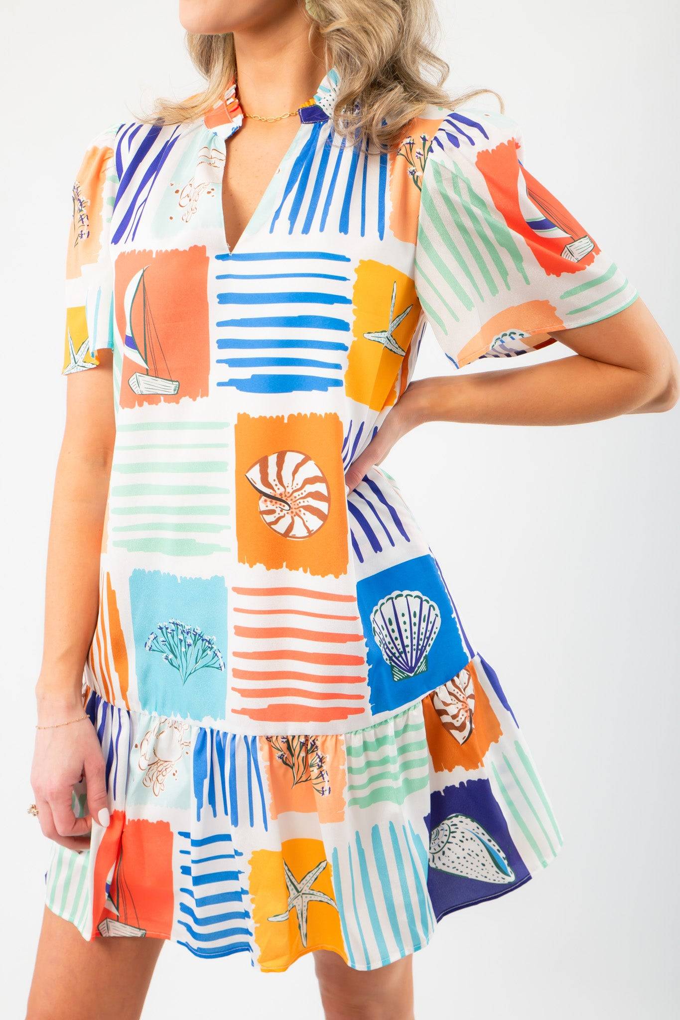 Close-up of THML At Sea Nautical Printed Dress showcasing vibrant nautical graphics, soft fabric, and tiered ruffle hem for summer style.
