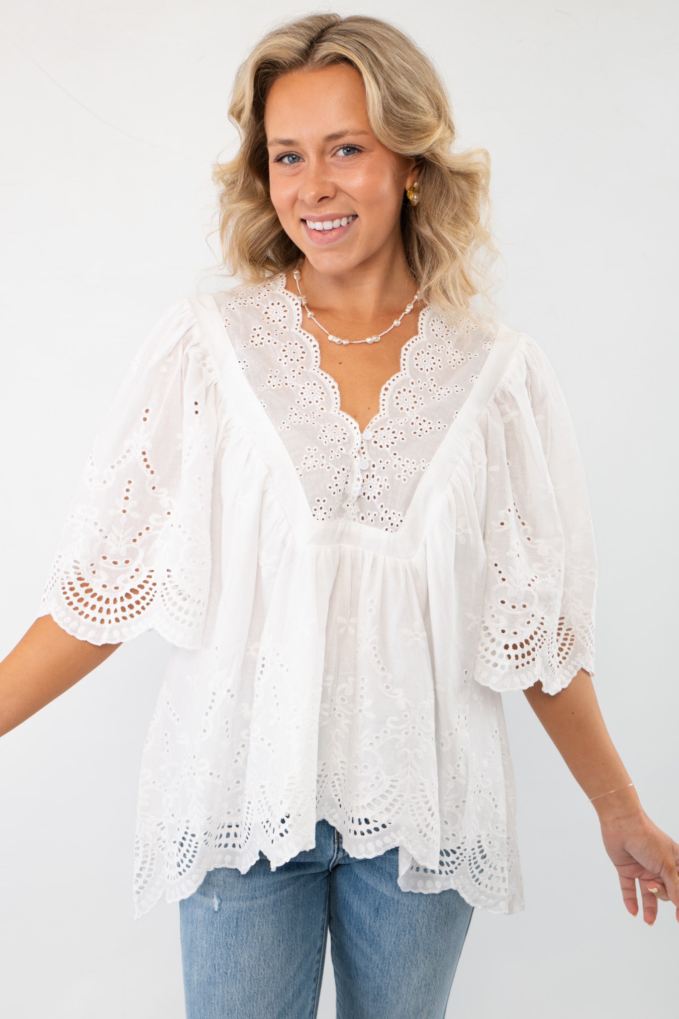 FA Off White Short Sleeve Eyelet Top WM with a feminine V-neckline and airy sleeves. A stylish and lightweight blouse for casual outings.