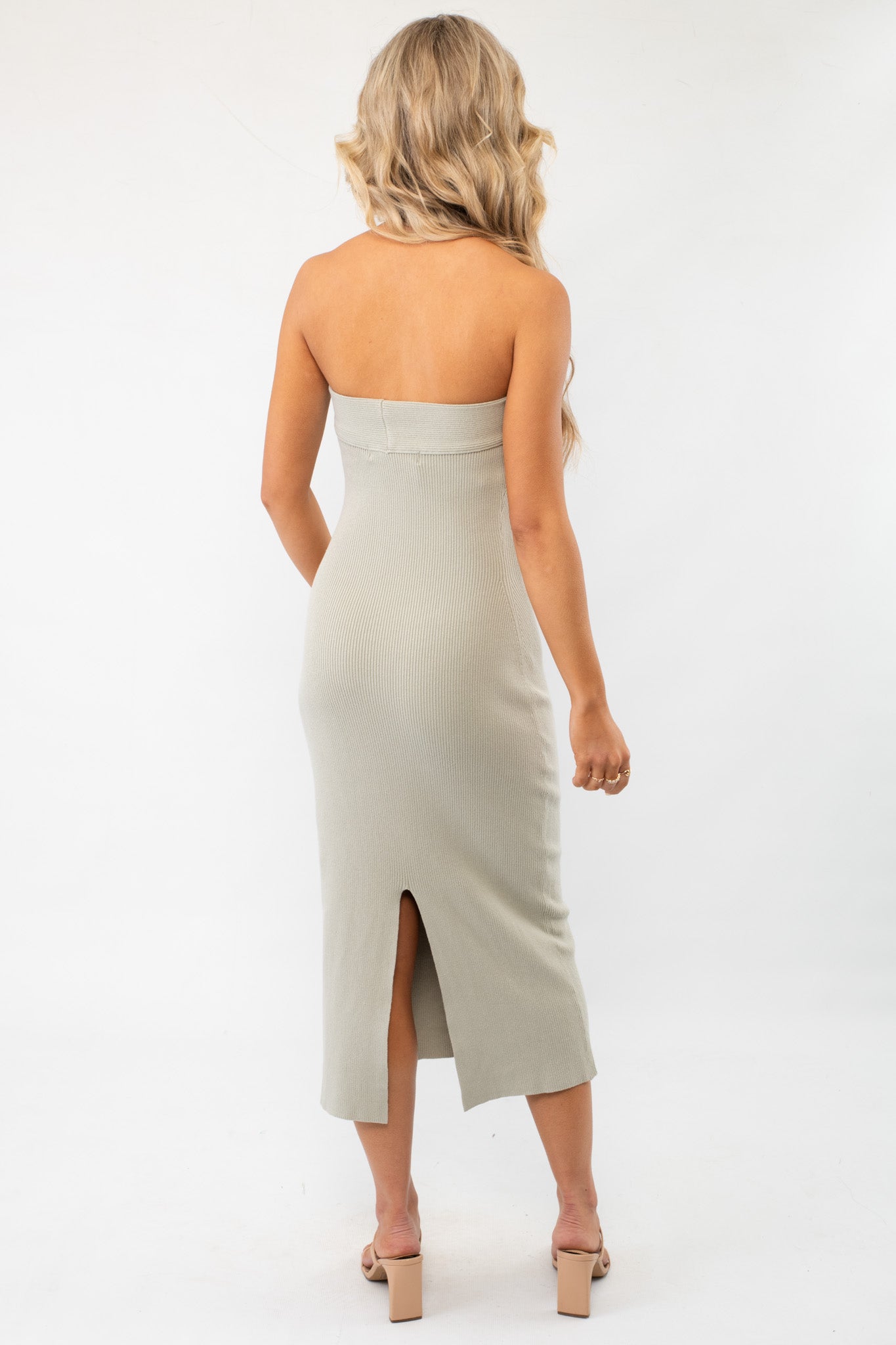 Back view of the Free People Butter Bean Ravena Sweater Midi Dress, showcasing a sleek silhouette with a back slit for added movement.