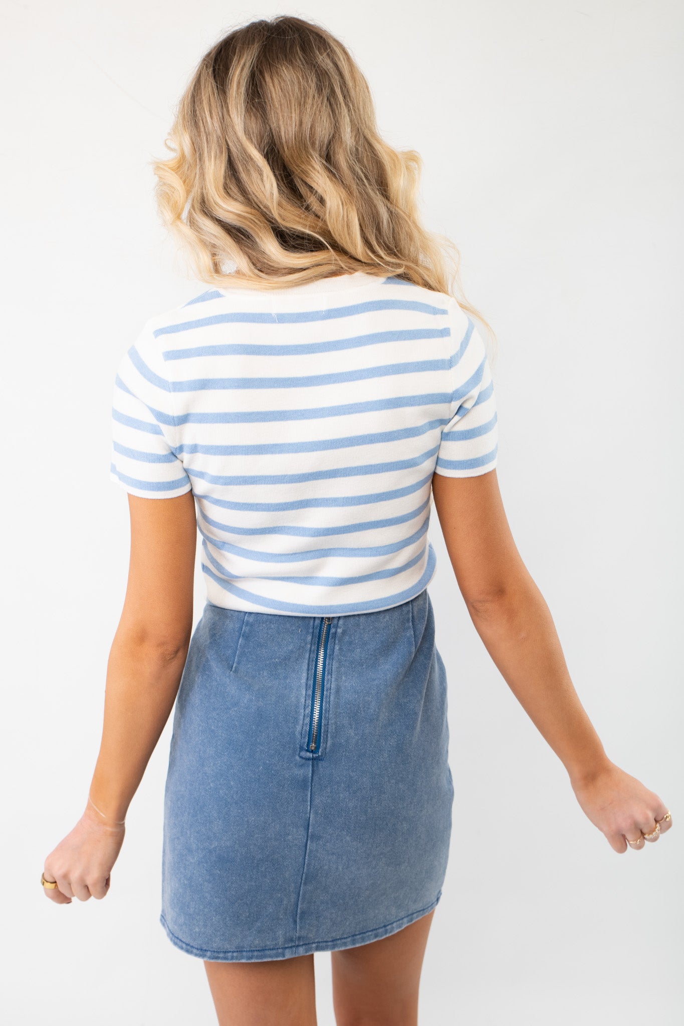 Back view of the Front Stitch Pocket Denim Skirt with a zip-up closure, offering a sleek and comfortable fit for effortless spring-to-summer styling.