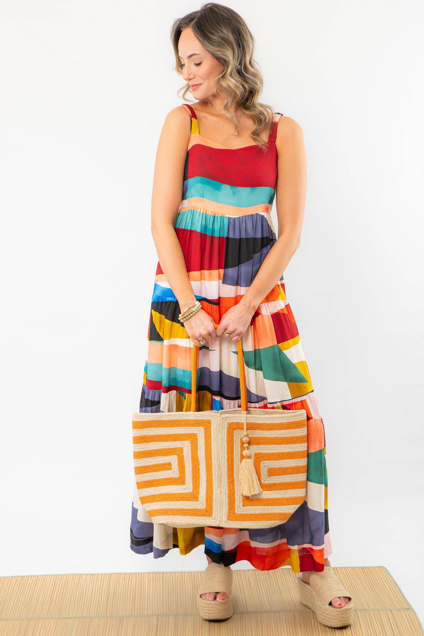 Fashionable color block maxi dress paired with a woven tote bag. A trendy and comfortable outfit choice for a girls&#39; trip or vacation.