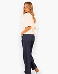 Rear angle of Heart Texture Cream Peplum Top styled with dark denim, emphasizing its flattering peplum silhouette and puffed sleeves.