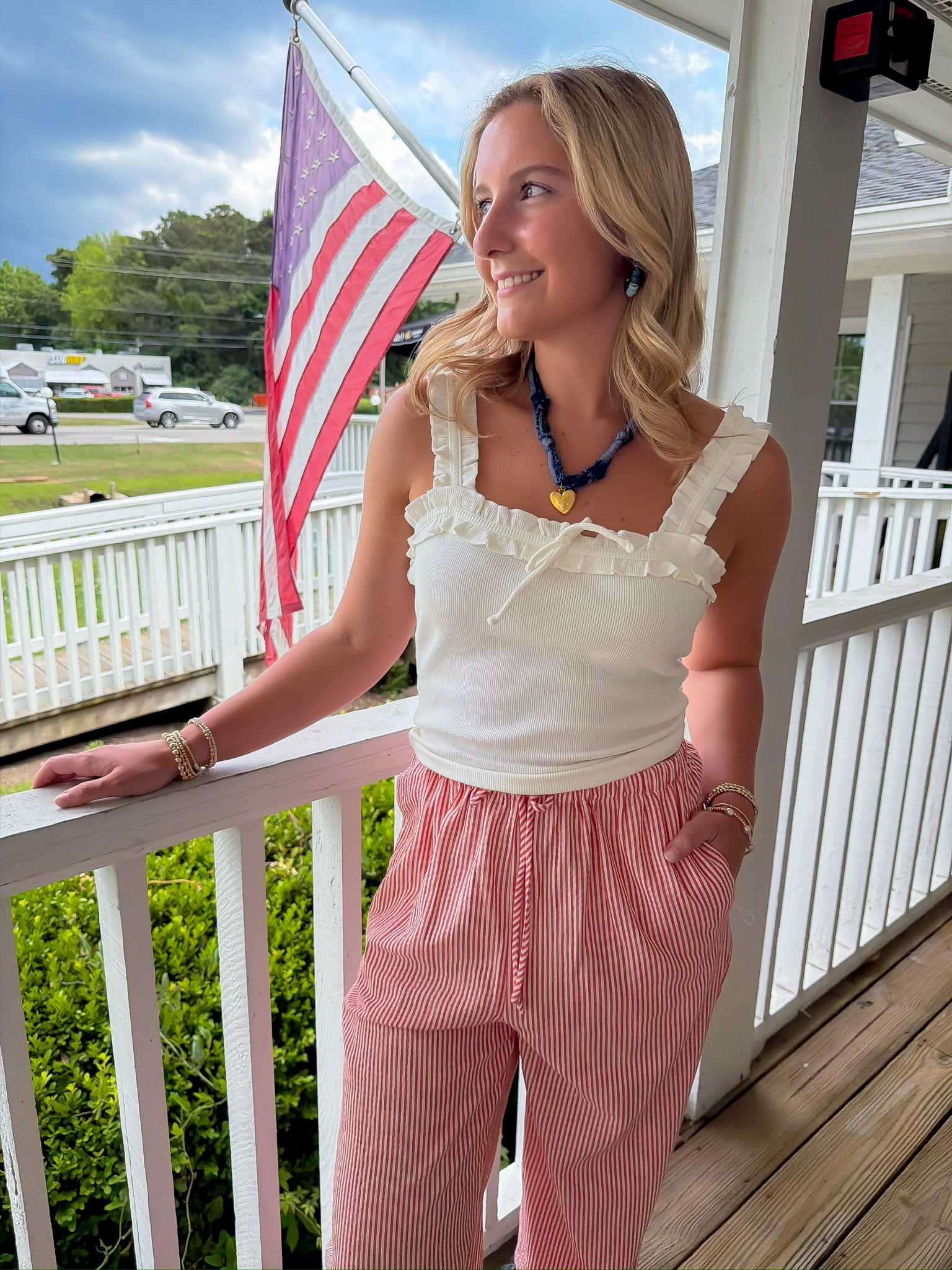 Woman standing on a porch with an American flag in the background
