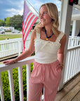Woman standing on a porch with an American flag in the background