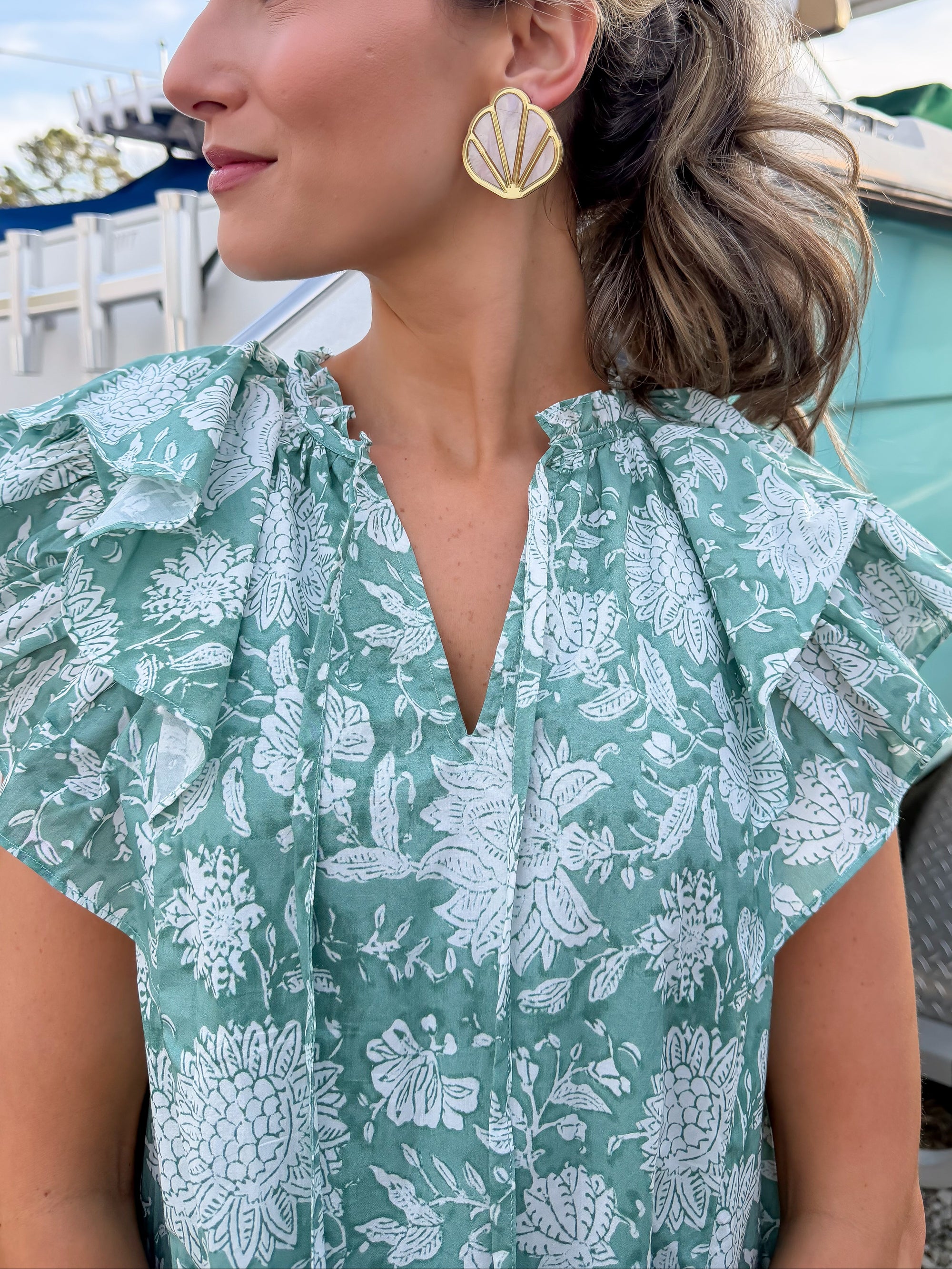 Woman wearing a green floral dress with a blurred background