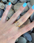 Close-up of Lucky Charm Gold Horseshoe Ring on finger, showcasing gold-plated finish and open horseshoe design with subtle detailing.