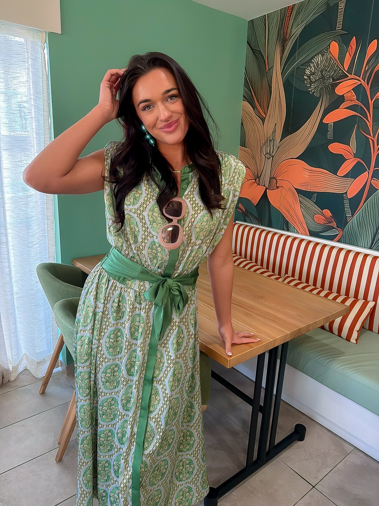 Printed satin midi dress in emerald with a flattering waist tie and vintage-inspired pattern, ideal for summer events.