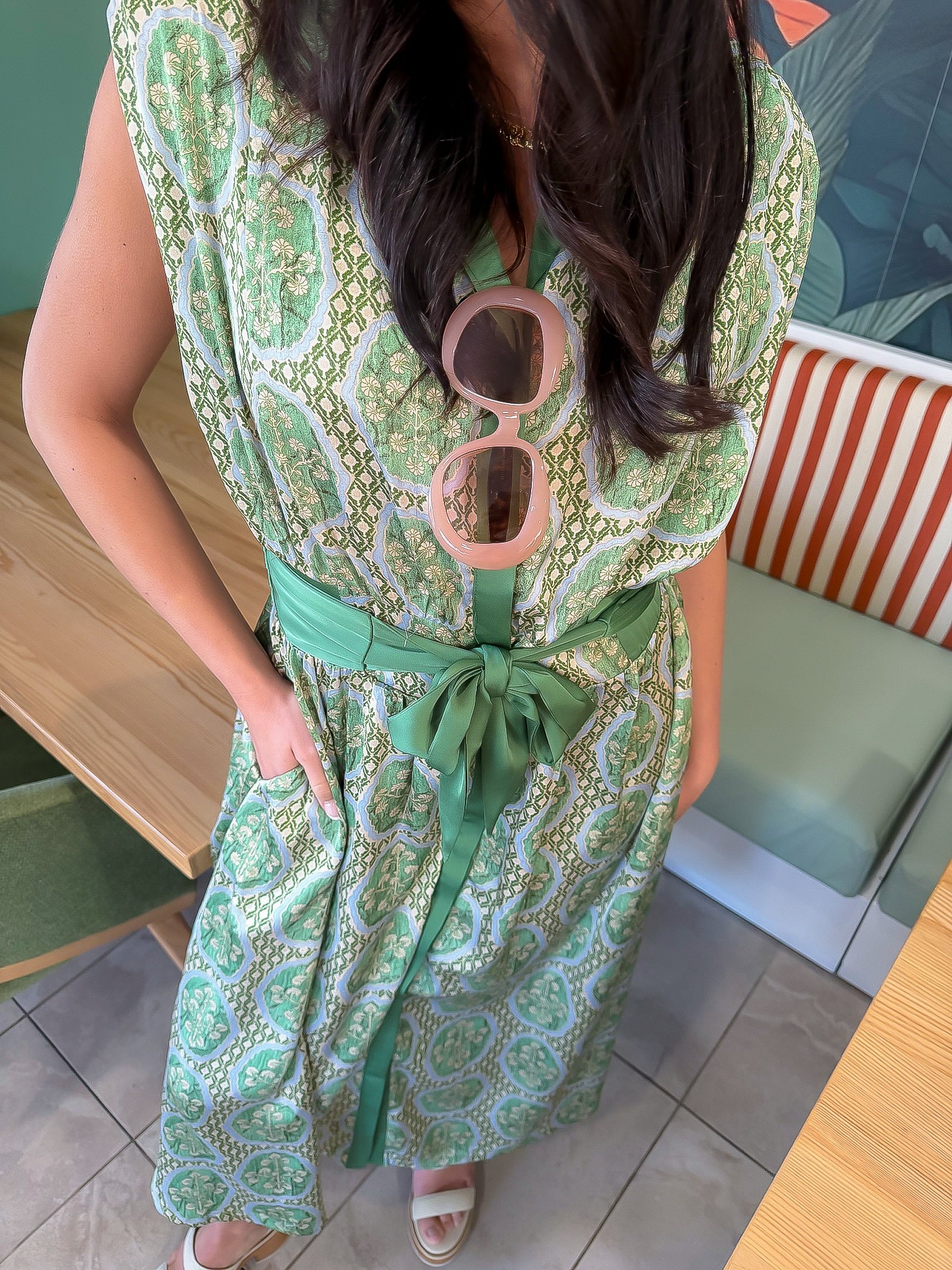 Emerald Deco Printed Satin Midi Dress with Art Deco pattern, green sash belt, and front buttons, styled for a chic daytime look.