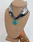 Moon Phase Necklace with Turquoise Lock on navy printed bandana scarf, styled on display bust for trendy jewelry accessory appeal.