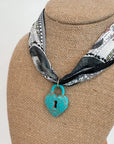 Close-up of Moon Phase Necklace featuring heart-shaped turquoise lock charm on celestial print bandana, perfect for fall fashion accessories.