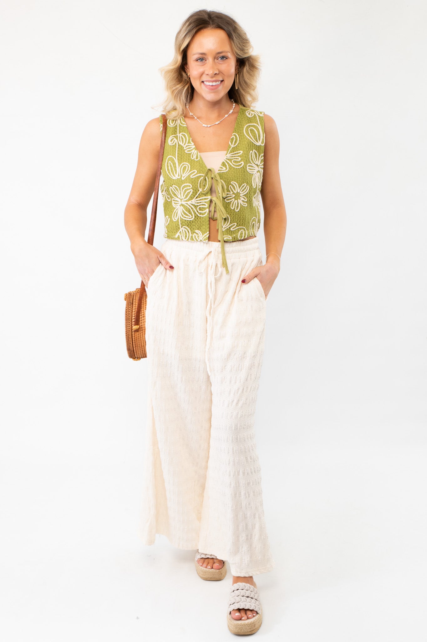 Model wearing the Jolene Matcha Embroidered Tie Top Vest styled with wide-leg pants for a breezy, coastal-inspired outfit. A perfect summer layering piece.