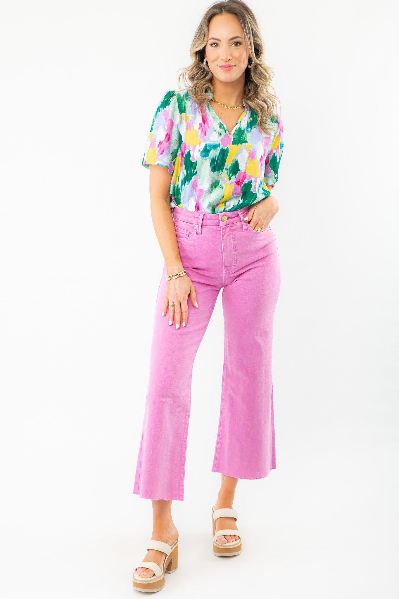 Model wearing KUT Peony Pink Meg High Rise Wide Leg Jeans, paired with a vibrant floral blouse and neutral platform heels. A stylish choice for spring events.