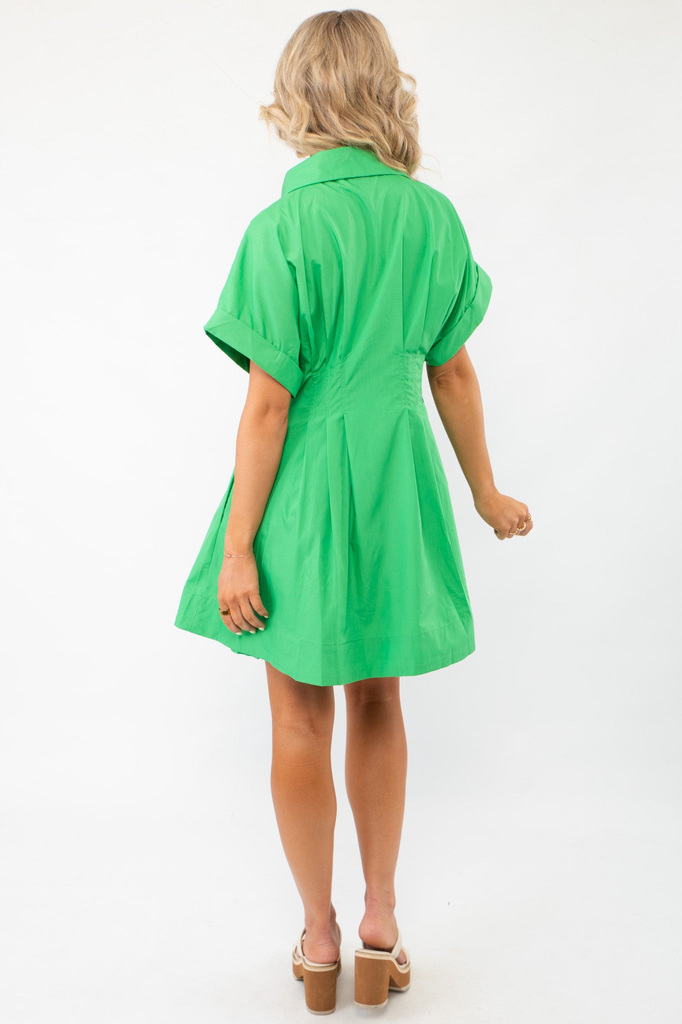 Back view of the Lucky You Kelly Green Button Up Mini Dress showcasing its tailored fit, pleated details, and stylish short sleeves.