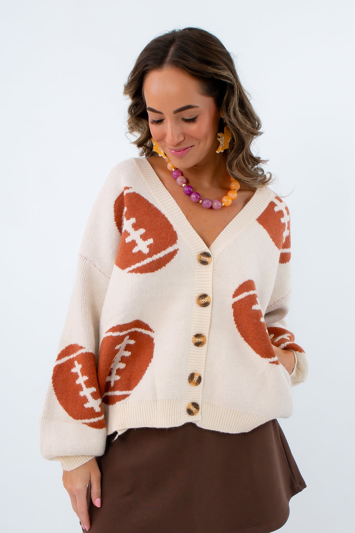 Neutral game day look oversized cardigan, sweater cardigan with footballs all over it