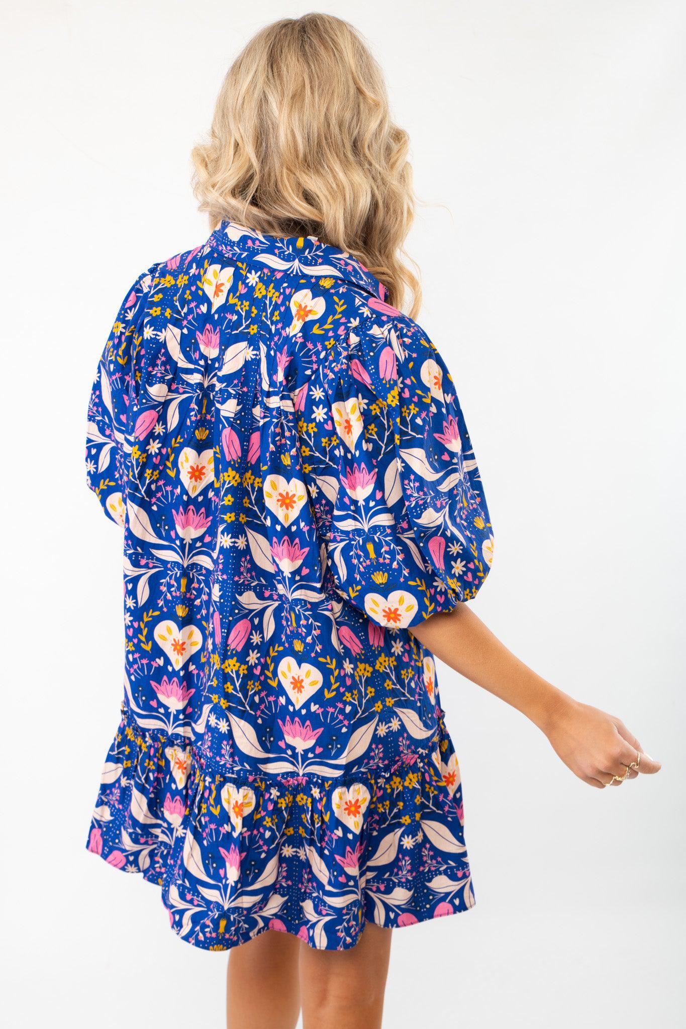 Back view of the Morgan Folk Love Mini Dress showcasing its relaxed fit, folk-inspired print, and stylish ruffle hem for a charming look.