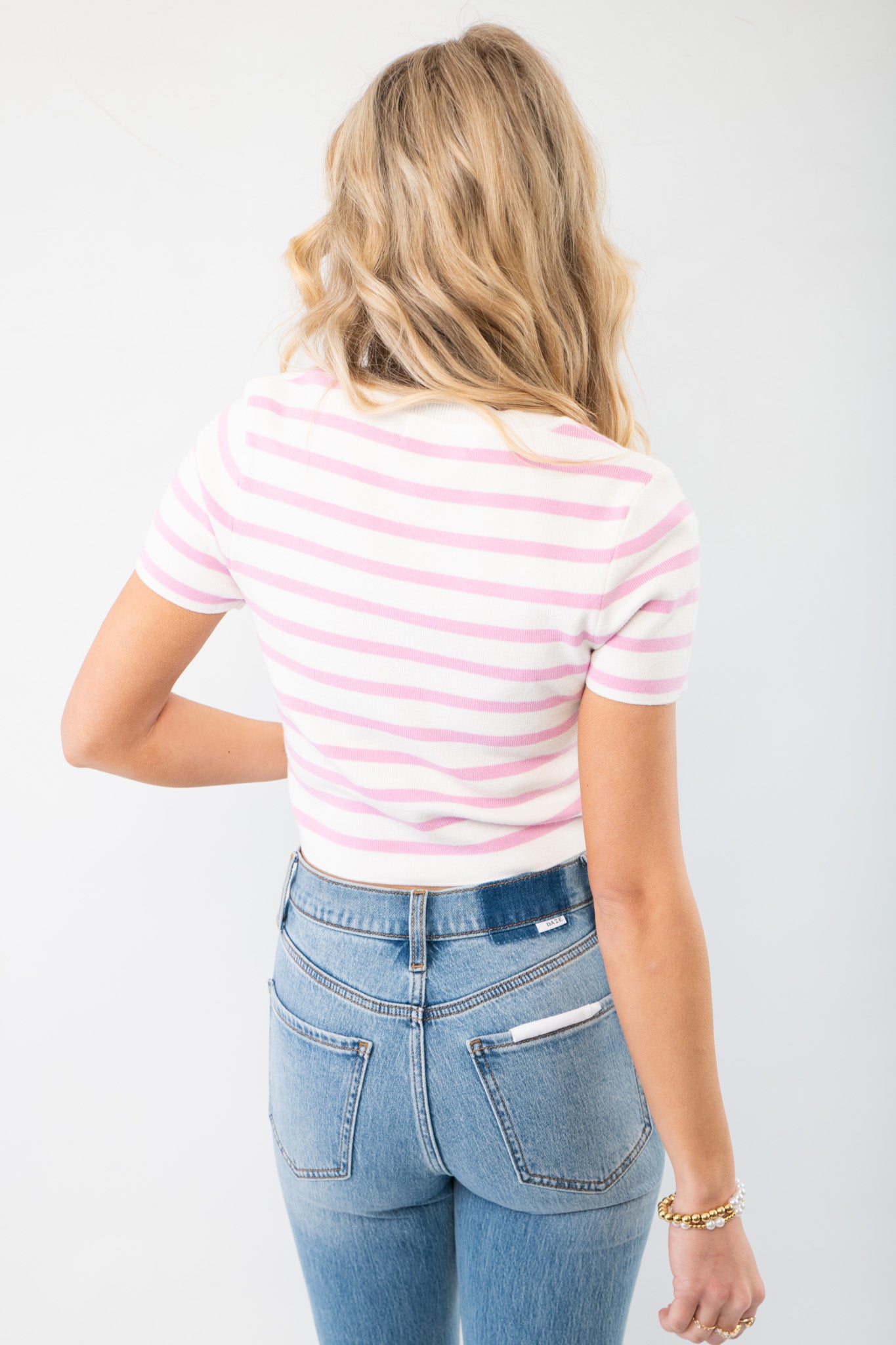 Back view of the Next Up Pink Striped Knit Crop Top showcasing its fitted silhouette and classic pink and white striped design. Ideal for stylish layering.