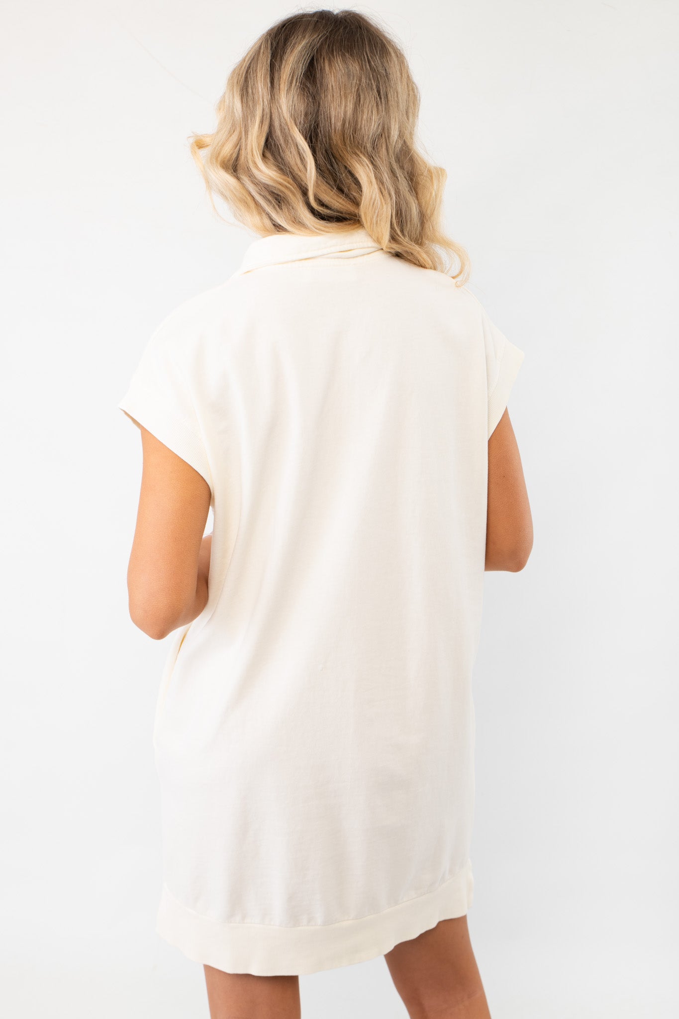 Minimalist and chic On the Go Cream Quarterzip Mini Dress from the back, highlighting its simple yet elegant design for everyday wear.