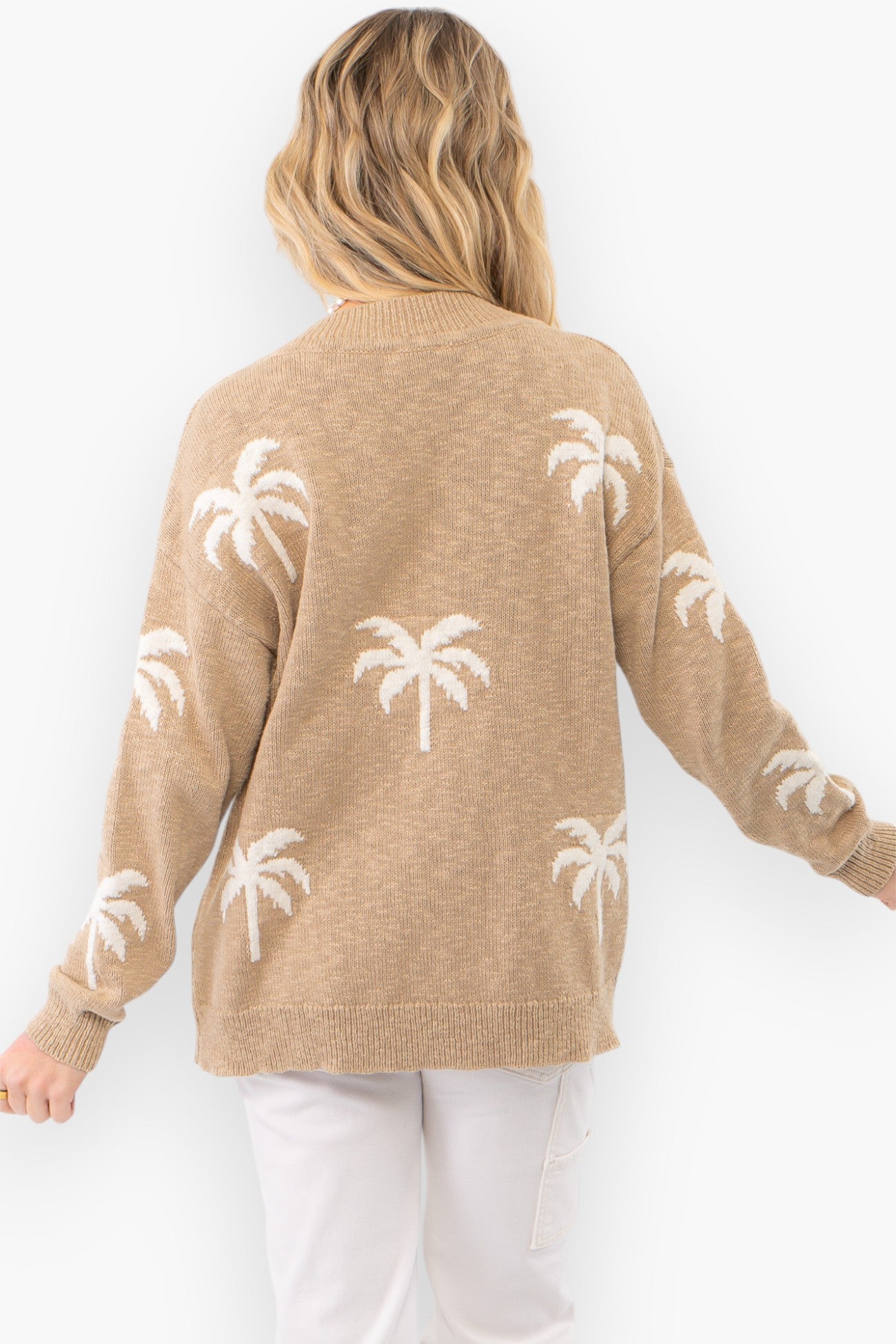 Close-up of the Palm Desert V-Neck Sweater in taupe, highlighting the intricate white palm tree design. Soft knit fabric with a flattering relaxed fit.