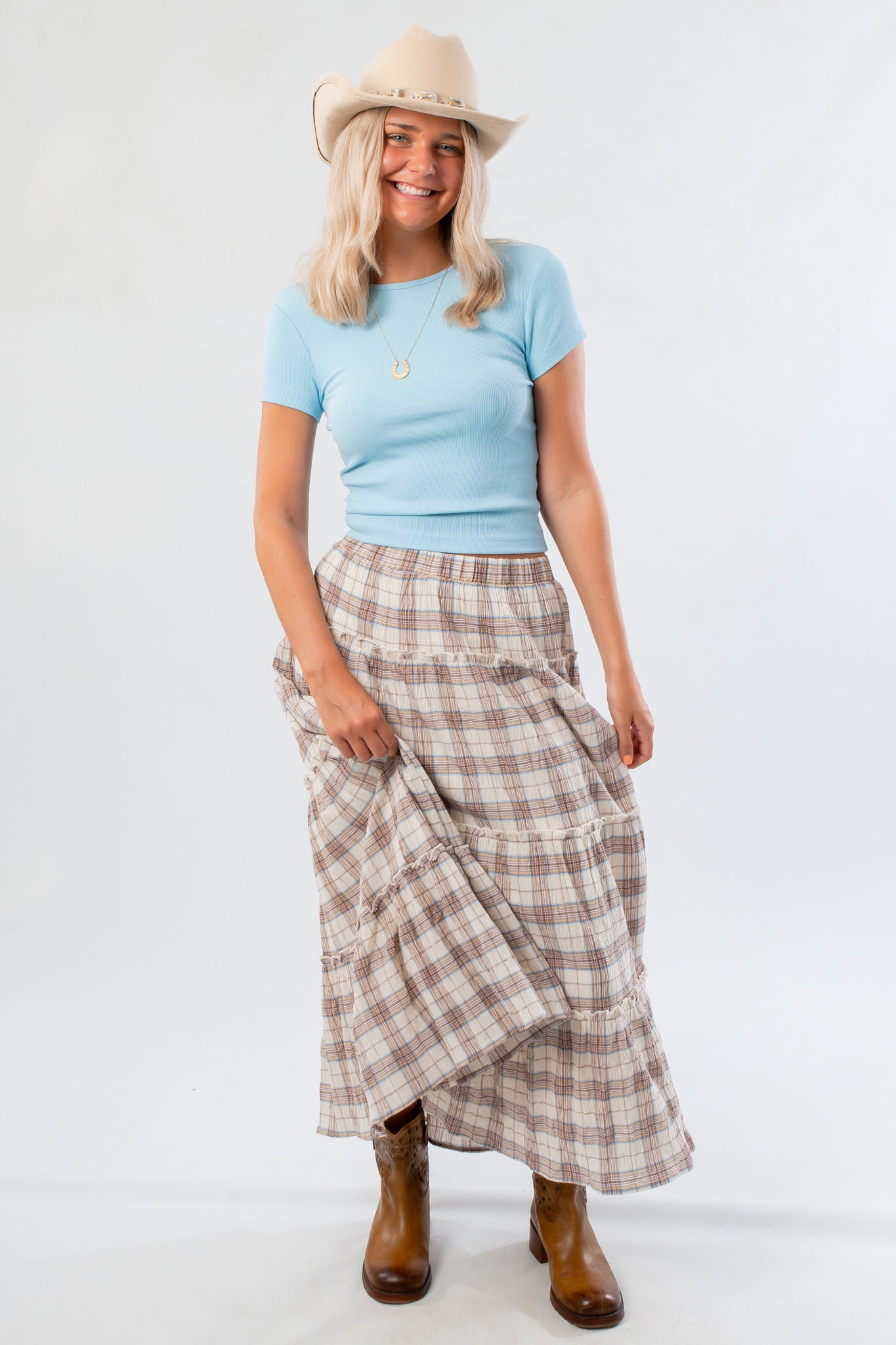 Front view of Fort Worth Brown Plaid Maxi Skirt styled with a blue top and tan boots, perfect for a rustic-chic wardrobe.