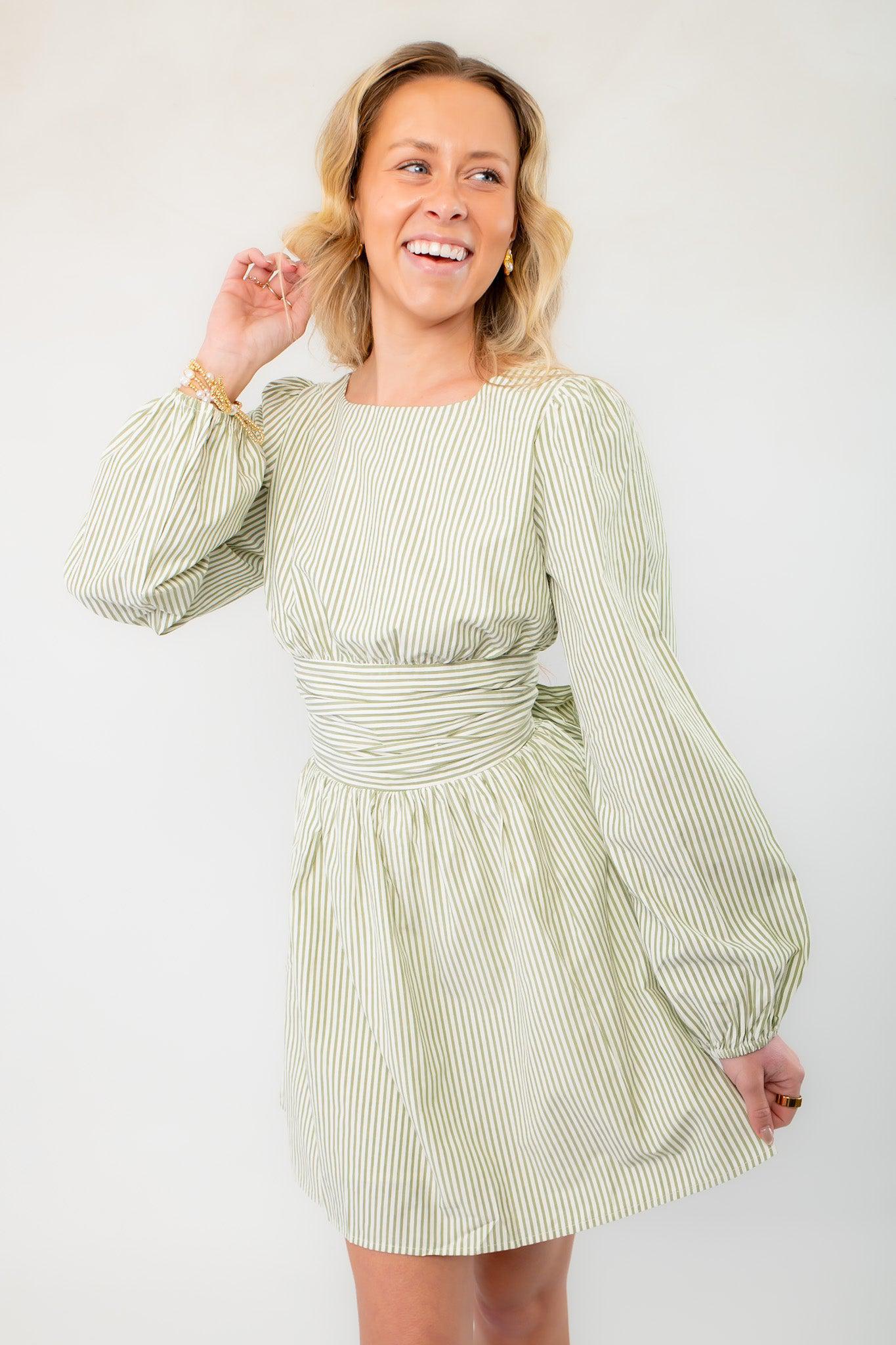 Sage striped mini dress with a cinched waist and balloon sleeves, perfect for a casual yet elegant spring or vacation outfit.