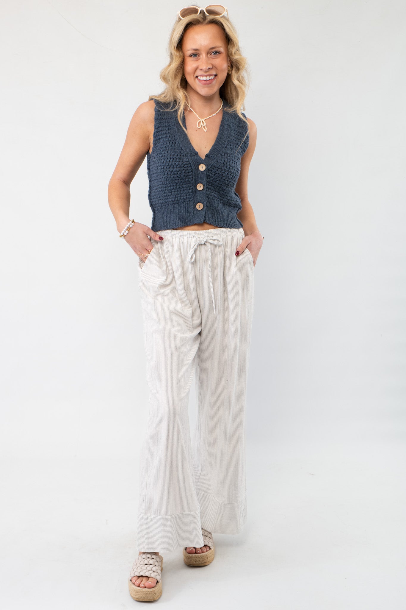 Shelly Wide Leg Black Striped Woven Pants styled with a navy knit vest, showcasing a casual yet sophisticated everyday look.