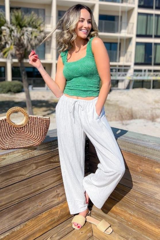 Shelly Wide Leg Black Striped Woven Pants with an elastic tie waist and cuffed hem, styled with a green crop top for a chic resort look.