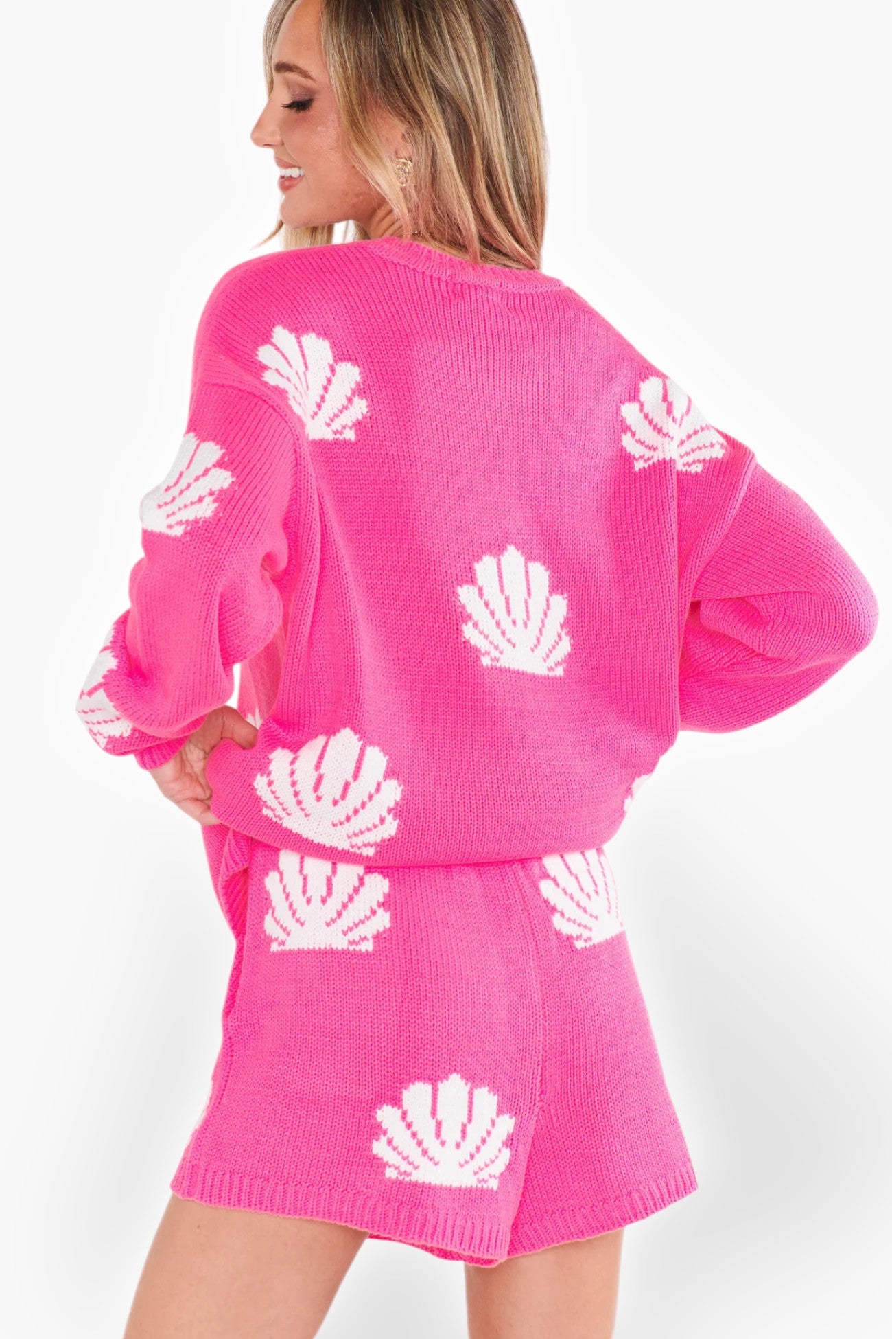 Back view of Show Me Your Mumu Hot Pink Shell Boardwalk Shorts, showcasing the white shell pattern and comfortable knit fabric for a chic resort look.