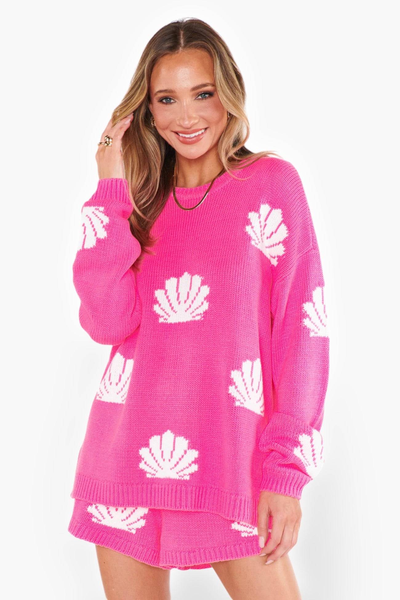 Model wearing the Show Me Your Mumu Hot Pink Shell Go To Sweater, styled with matching shorts. A cozy and stylish pick for vacations and breezy evenings.