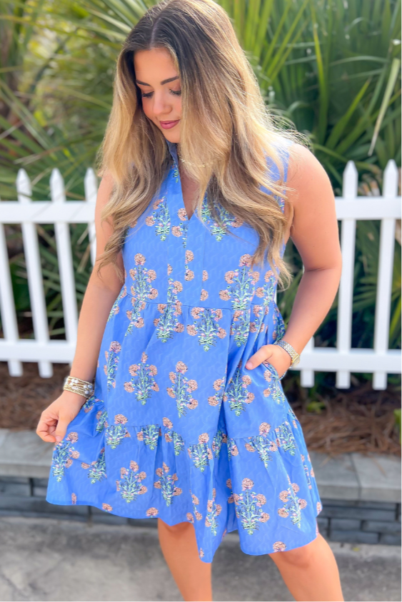 Close-up of the THML Blue Floral Sleeveless Tiered Mini Dress, featuring intricate floral prints, a V-neckline, and a breezy, comfortable fit.