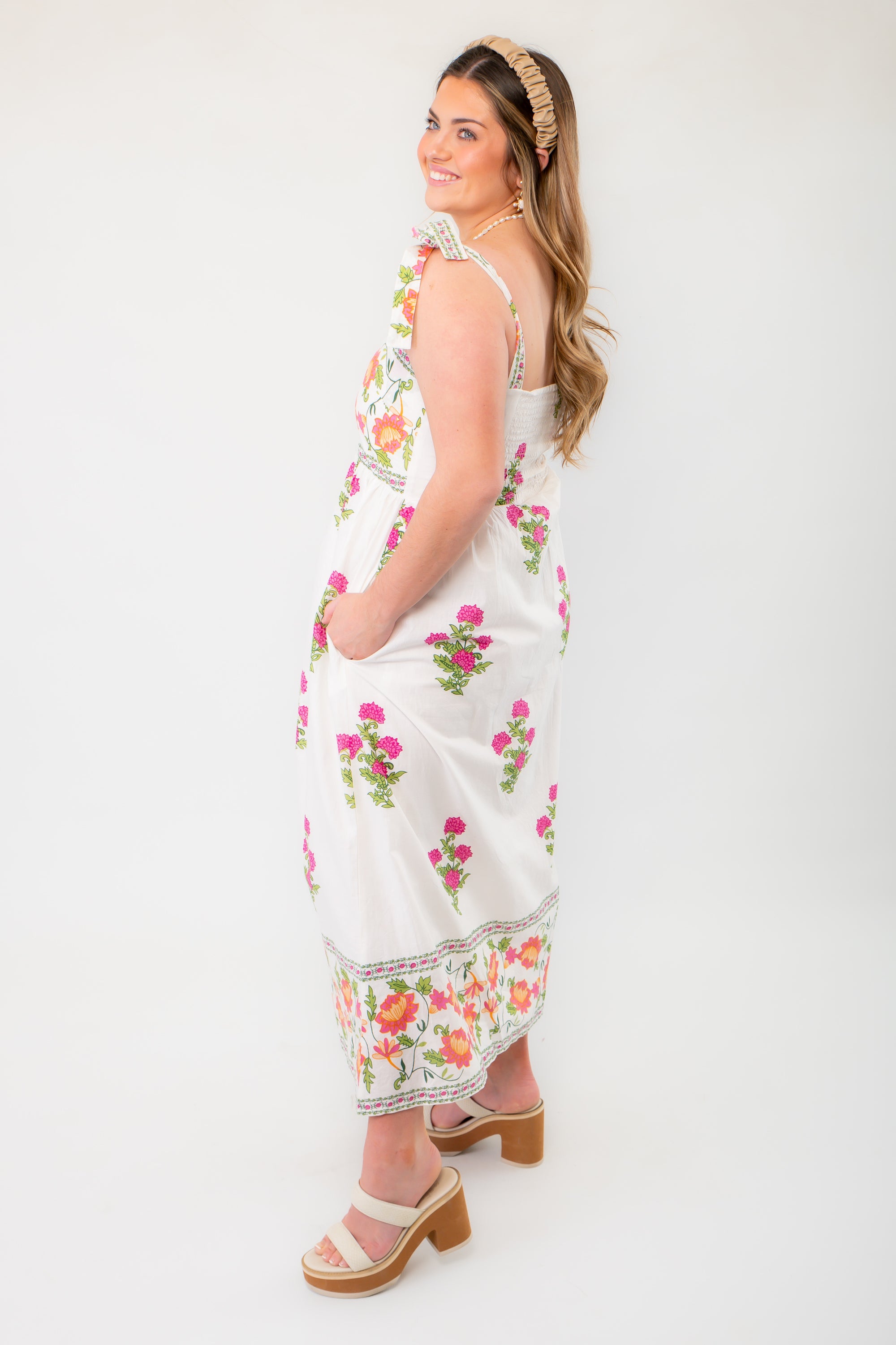 Side view of THML Vintage Floral Cream Button Down Midi Dress, highlighting its elegant silhouette and functional pockets.