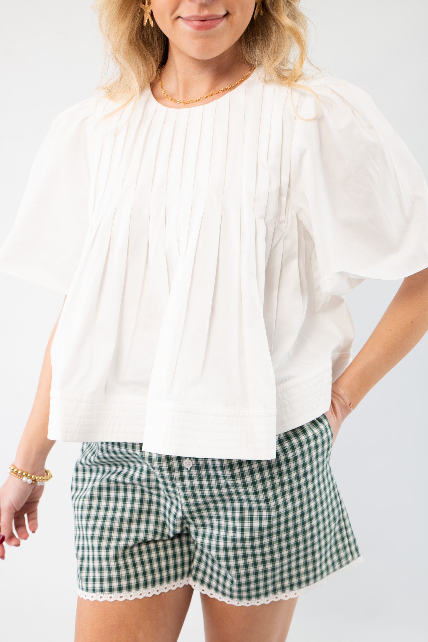 Close-up of the In This Moment Ivory Pleated Blouse, showcasing its elegant pleats and crisp white fabric for effortless style.