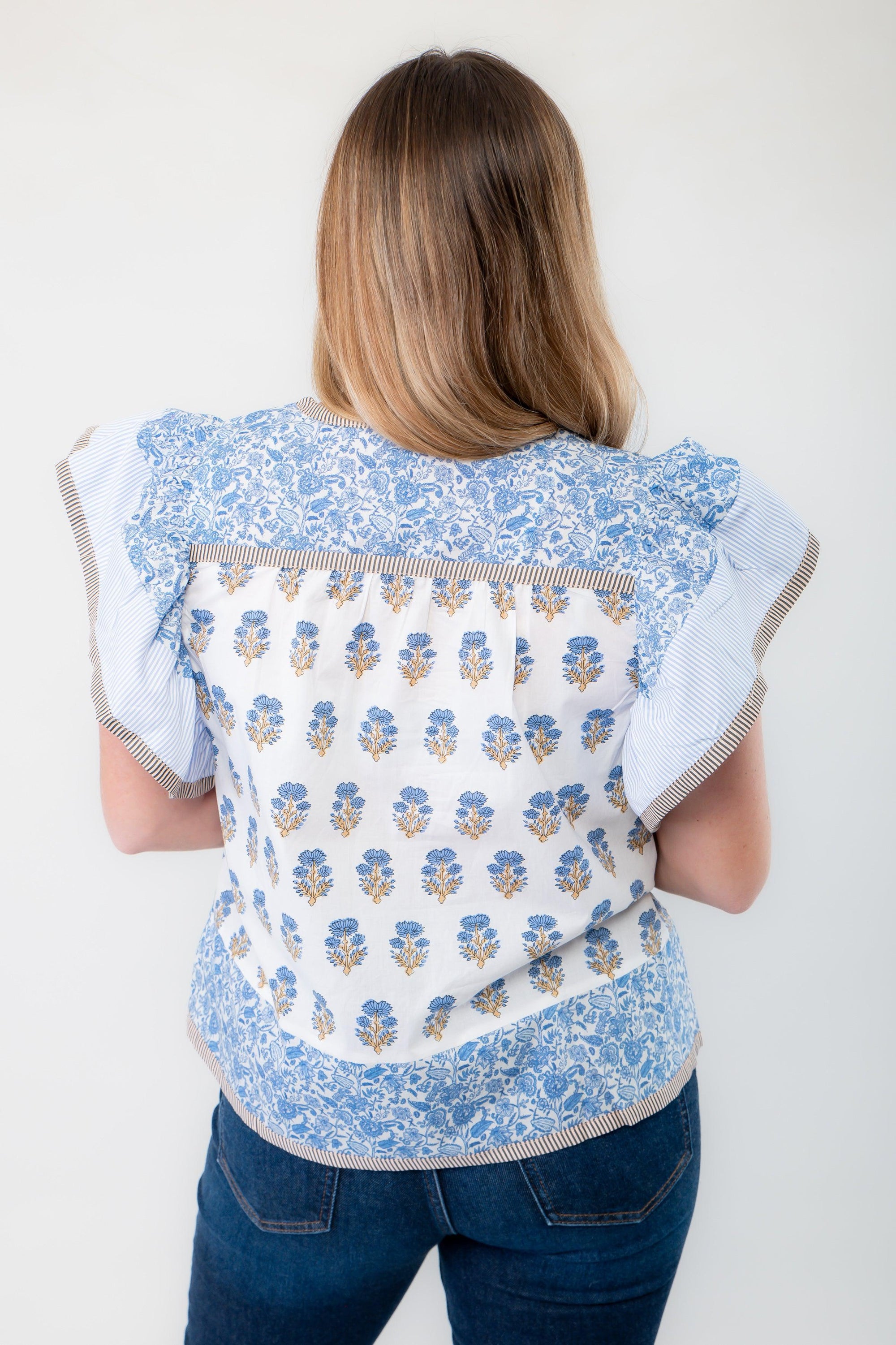 Back view of the Wildflower Ivory &amp; Blue Printed Ruffle Sleeve Top, featuring a mix of floral and striped patterns with ruffle sleeve accents.