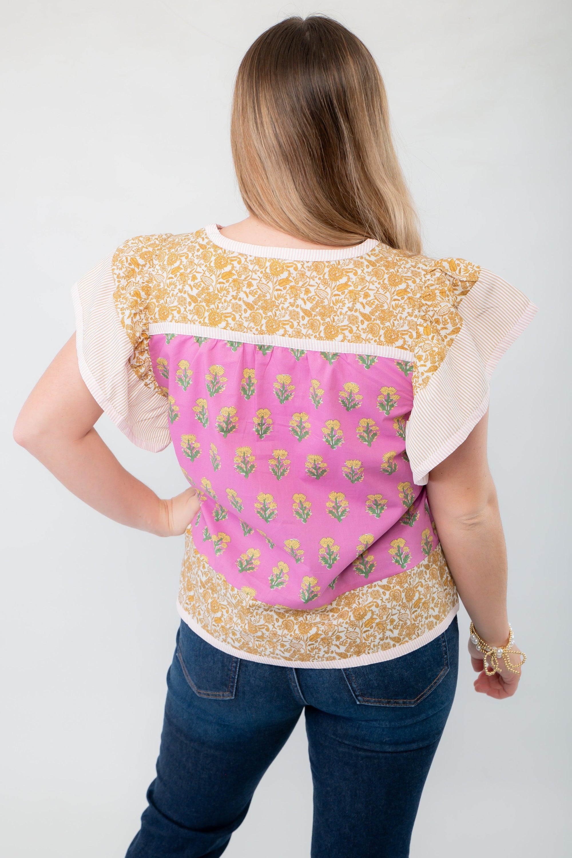 Back view of the Wildflower Pink &amp; Mustard Printed Ruffle Sleeve Top, featuring a charming floral pattern and stylish ruffle sleeve details.