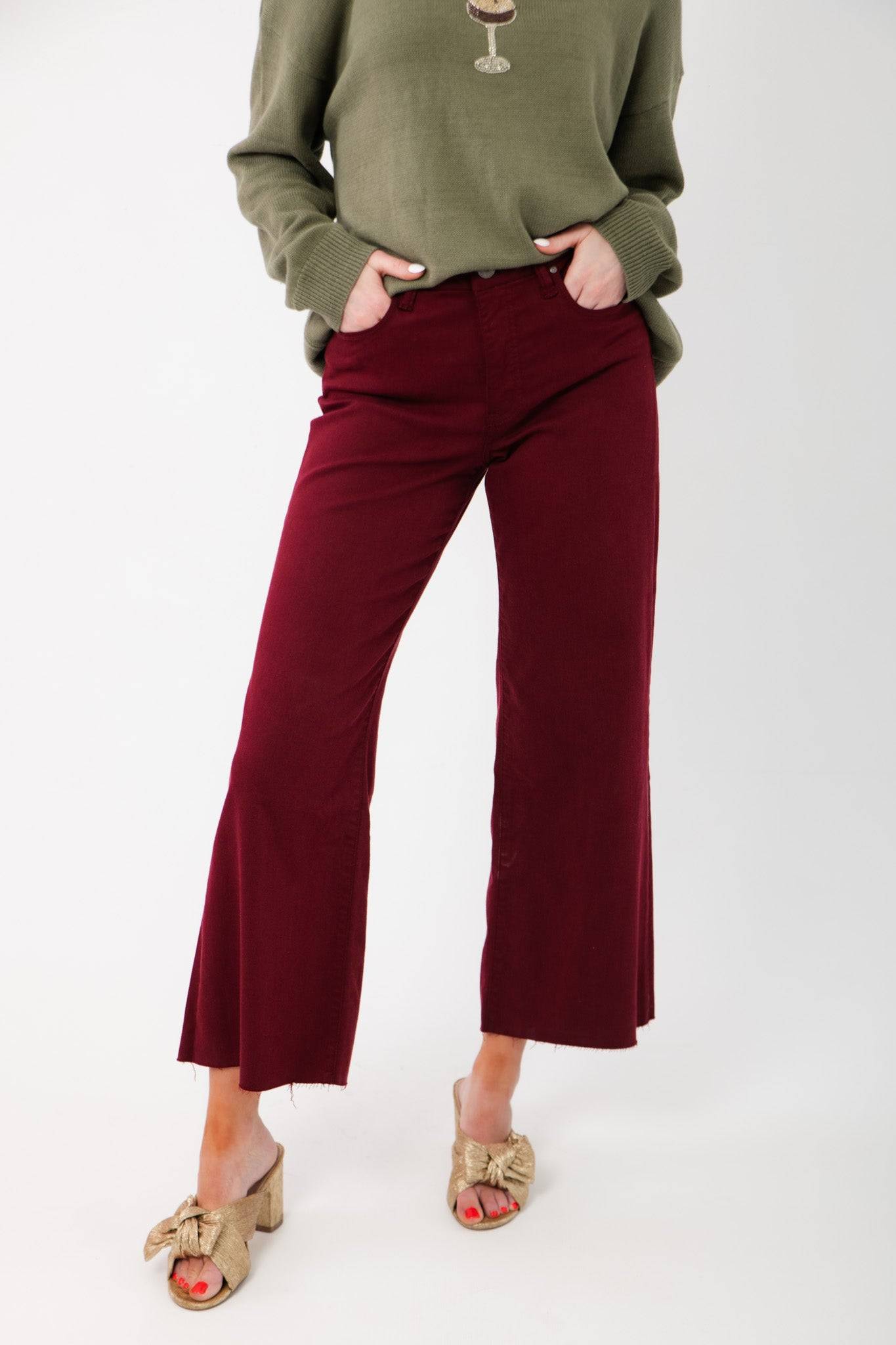 Kut Maroon Meg High Rise Wide Leg Jeans paired with an olive sweater and gold bow heels. Features frayed hem and flattering high waist.