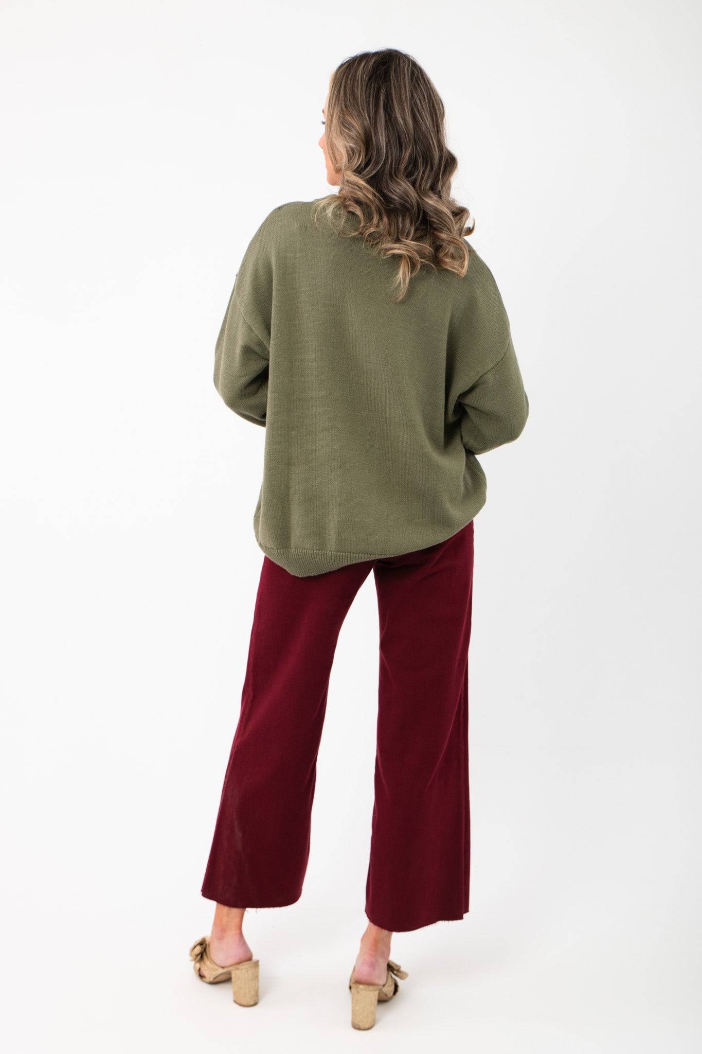 Back view of the Martini A Day Olive Beaded Sweater showing relaxed fit and ribbed hem. Perfect for layering in stylish holiday outfits.