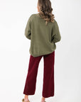 Back view of the Martini A Day Olive Beaded Sweater showing relaxed fit and ribbed hem. Perfect for layering in stylish holiday outfits.